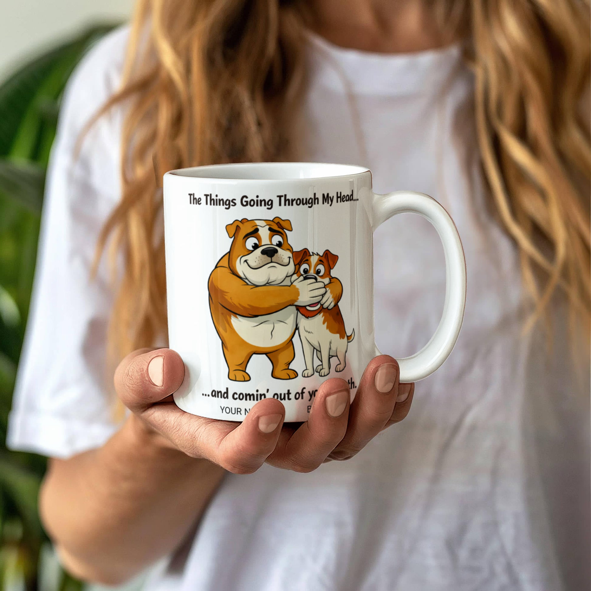 Person holding a mug with cartoon bulldogs and humorous text
