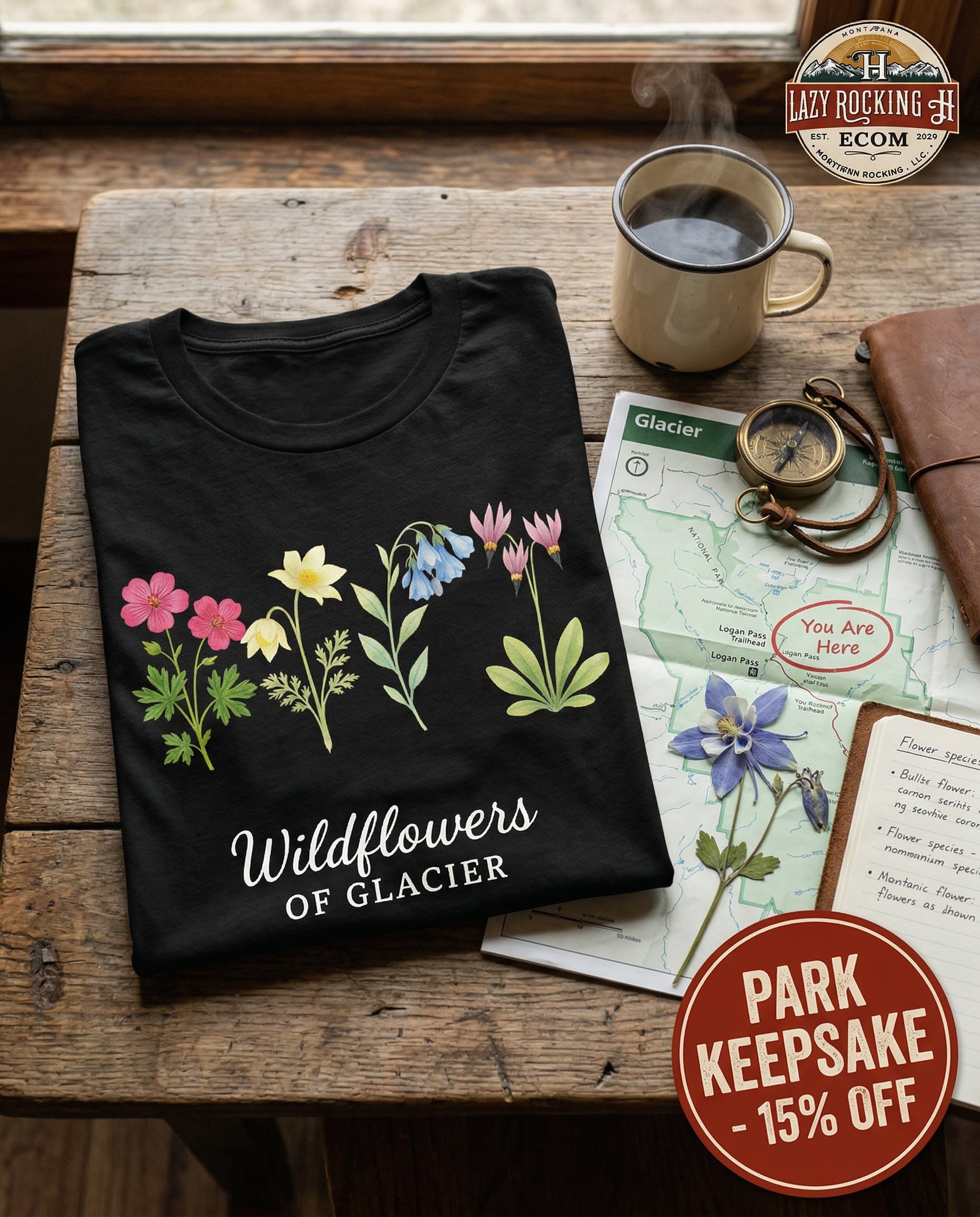 Black t-shirt with floral design and text on a wooden table with coffee and map.