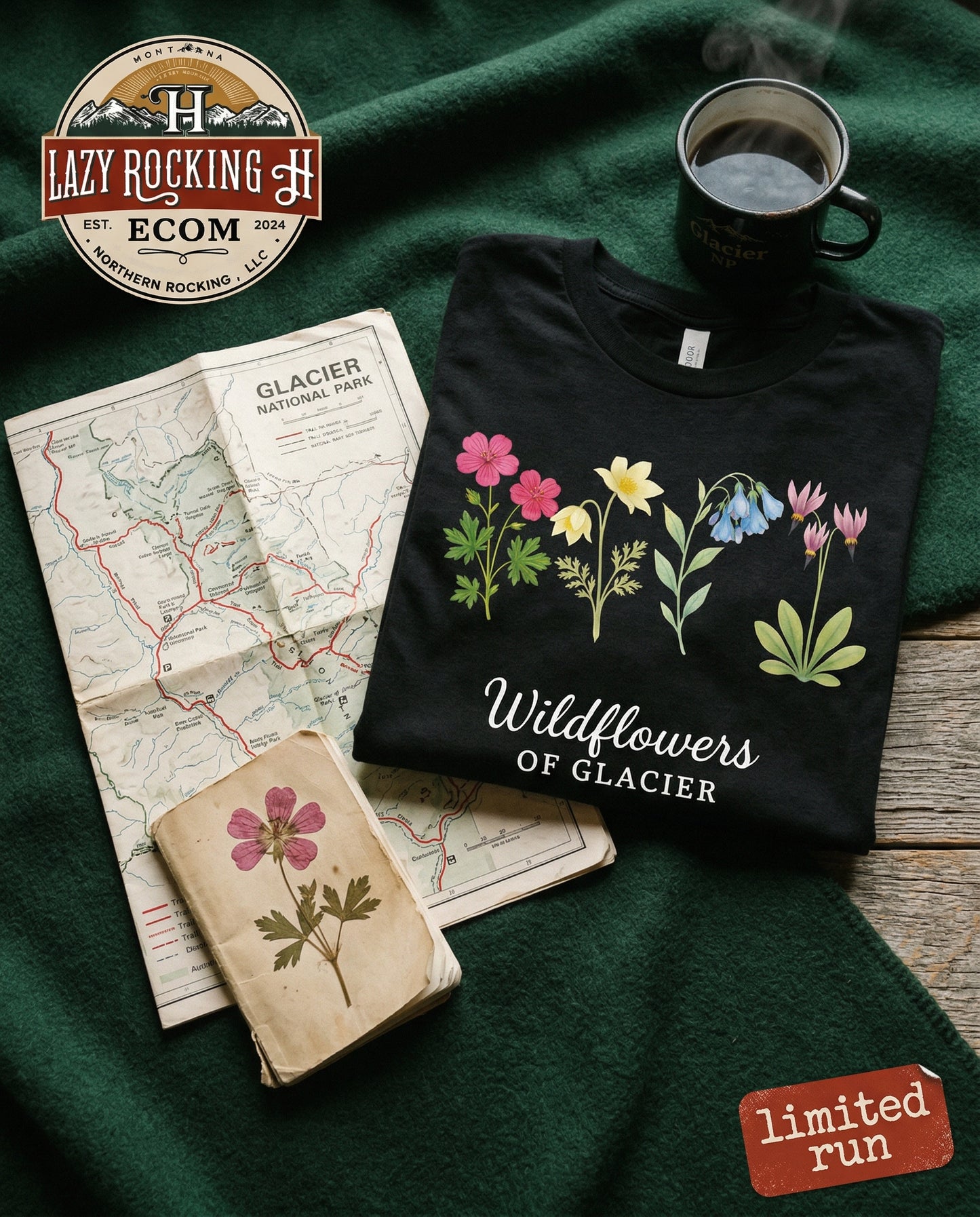 Black t-shirt with floral design and text, placed on a green surface with a map and coffee cup.